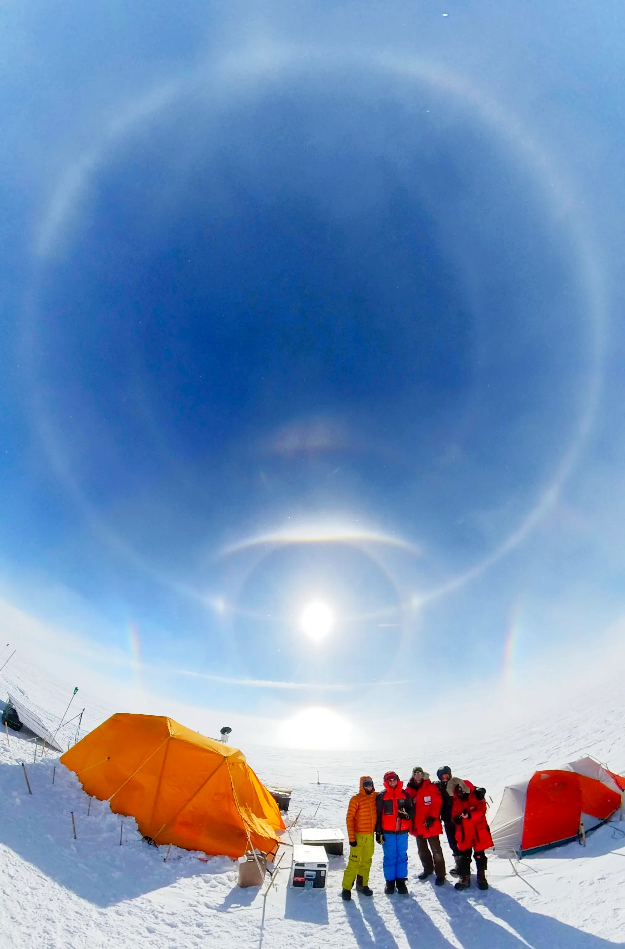 The install team standing in front of a large display of optical phenomena in Raven Greenland