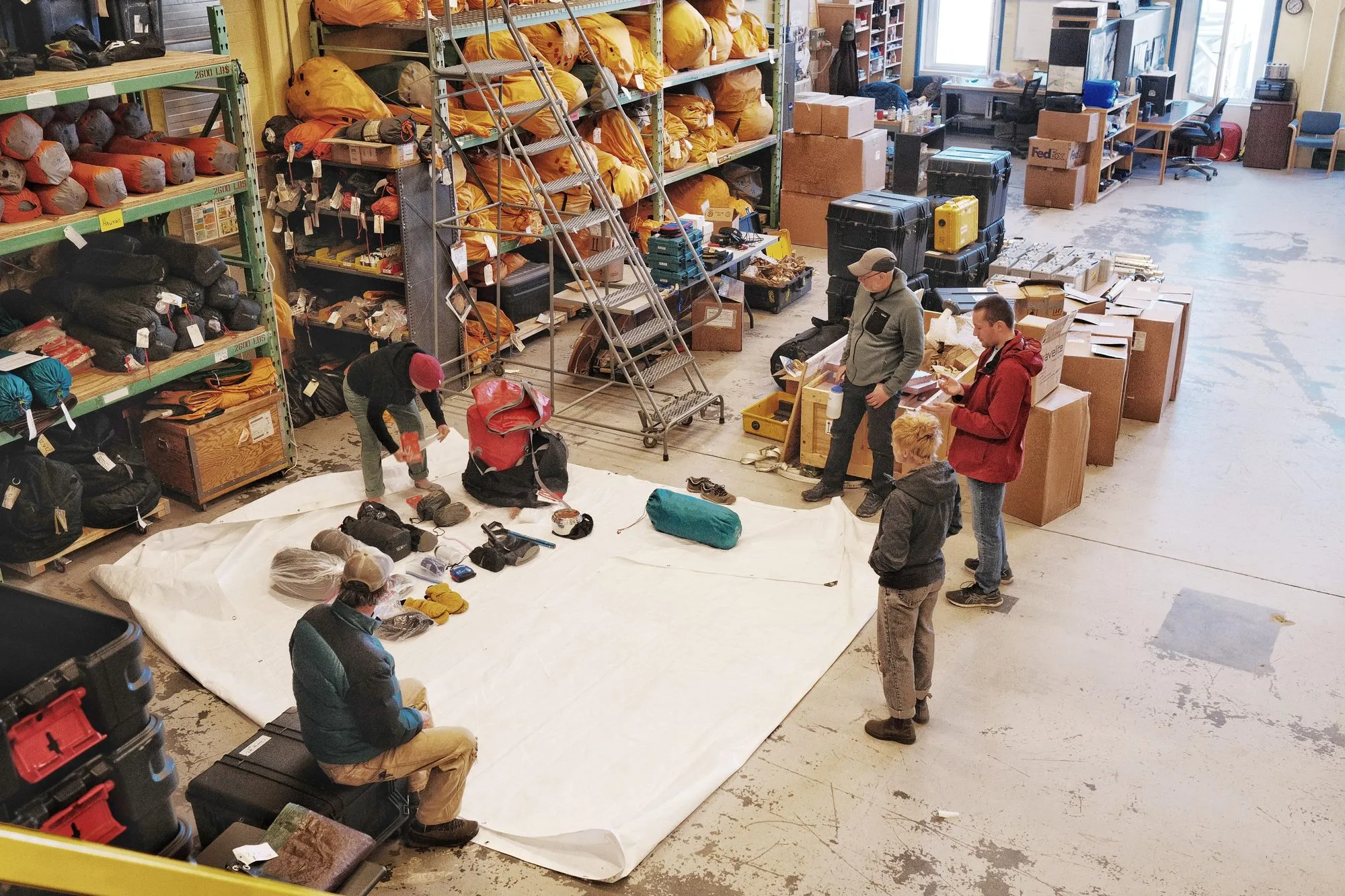 Checking out and inventorying the survival bags in the warehouse before the trip.