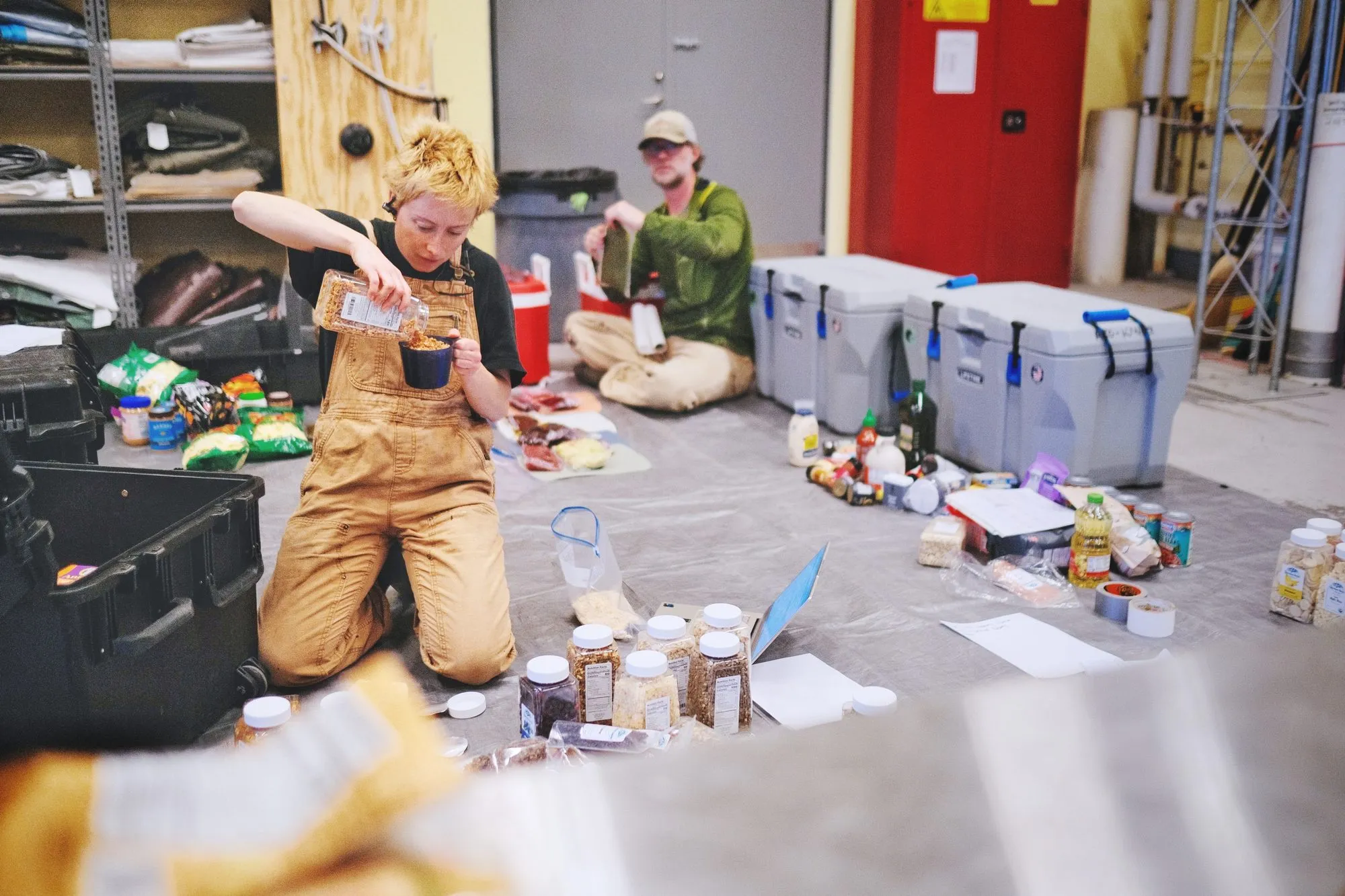 Cat and Matt are counting the jars of food on the floor in the warehouse